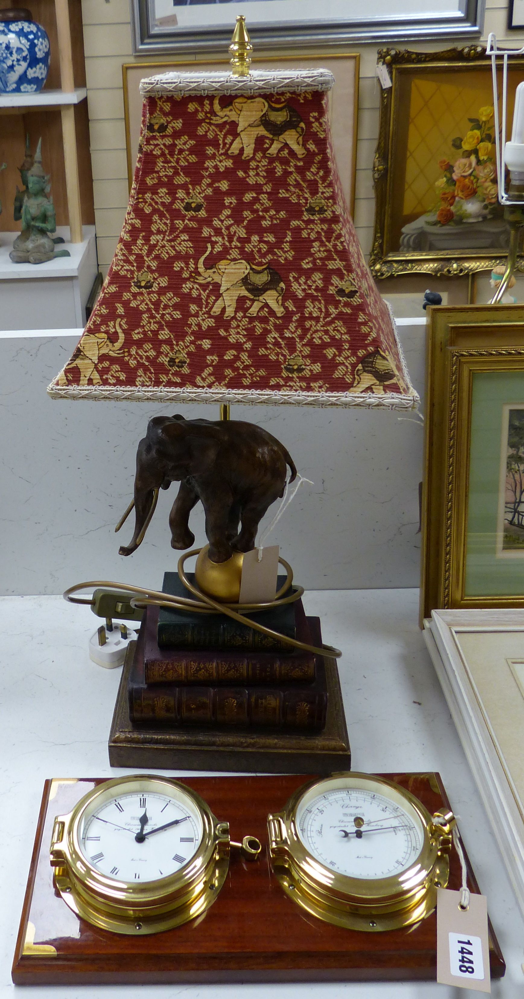 A Wempe wall-mounted ship's style clock/barometer and an 'elephant on books' table lamp